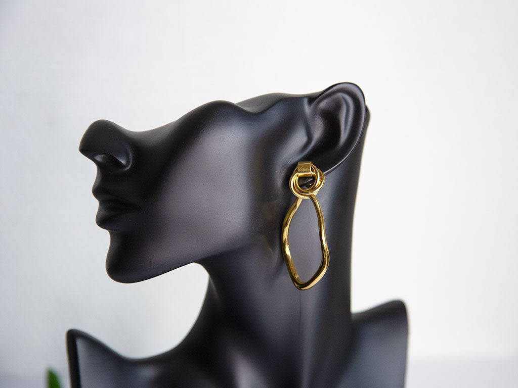 Boucles d’oreilles pendantes dorées ovales irrégulières en acier inoxydable – bijou élégant Lidiar Collection, présentées sur une tête de mannequin