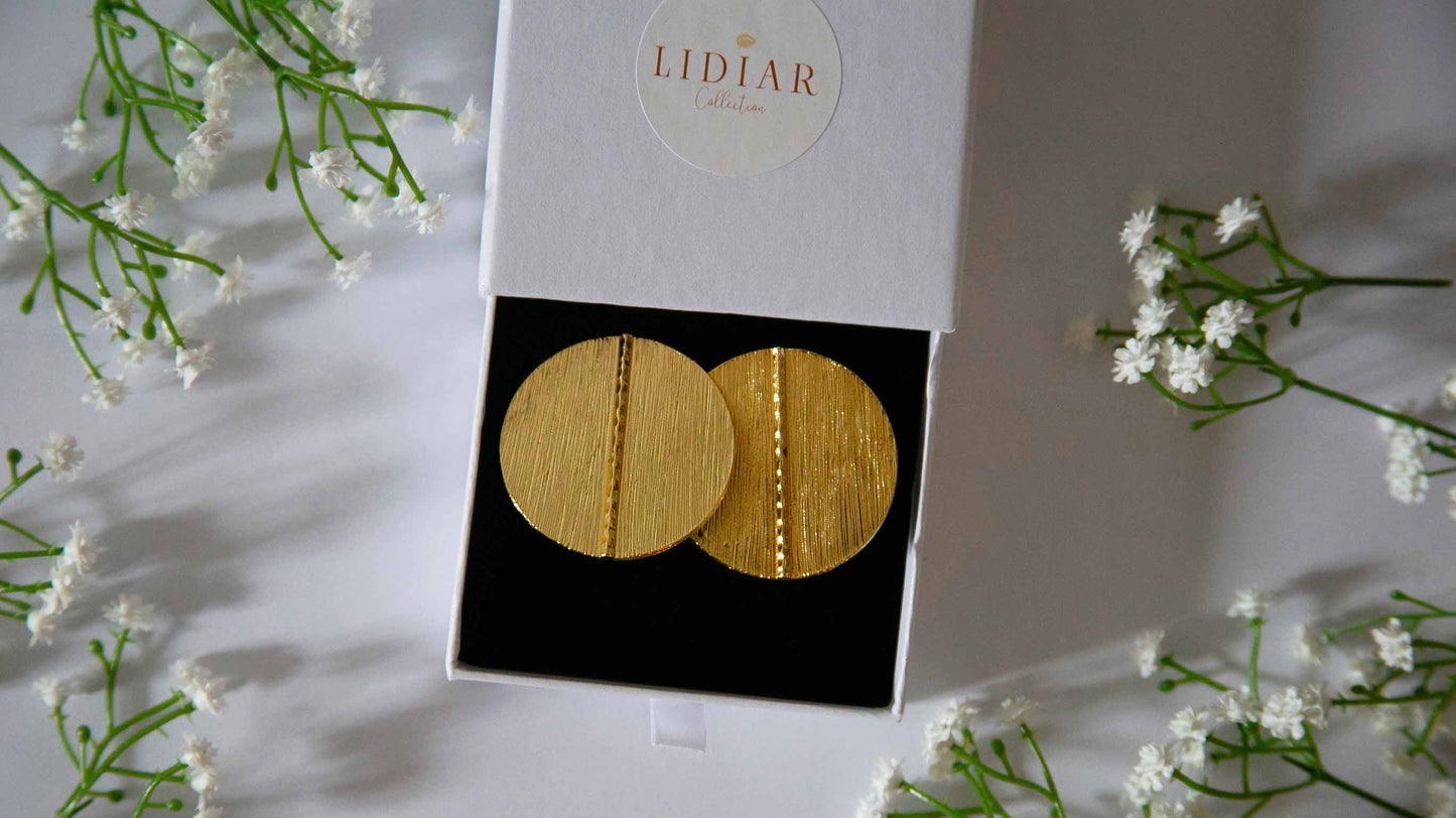 Boucles d'oreilles ethniques rondes dorées dans un écrin à bijoux Lidiar Collection