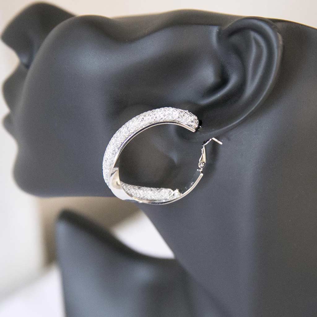 Tête de mannequin portant une boucle d'oreille argentée avec des strass