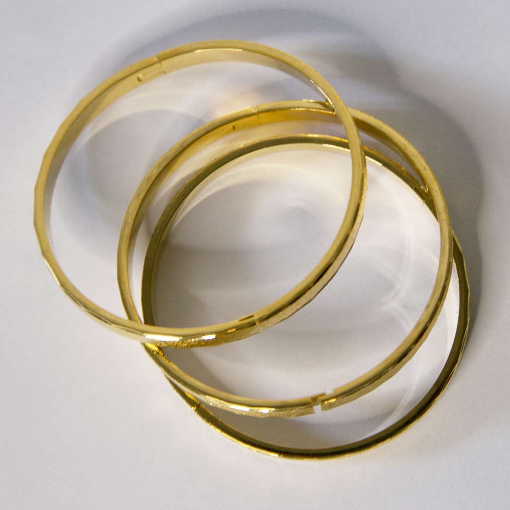 Trois bracelets en forme de cercle, doré, en acier inoxydable