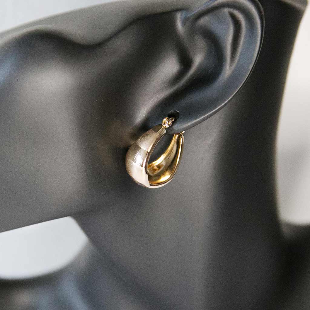 Tête de mannequin portant une boucle d'oreille simple, dorée en acier inoxydable
