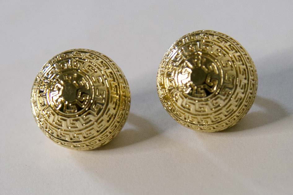 Boucles d'oreilles dorées en forme de boule avec des motifs géométriques
