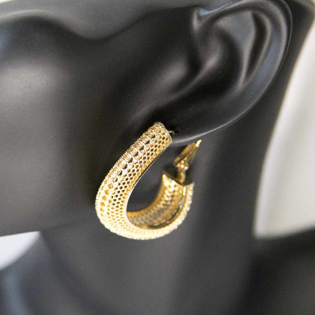 Tête de mannequin portant une boucle d'oreille dorée, en acier inoxydable
