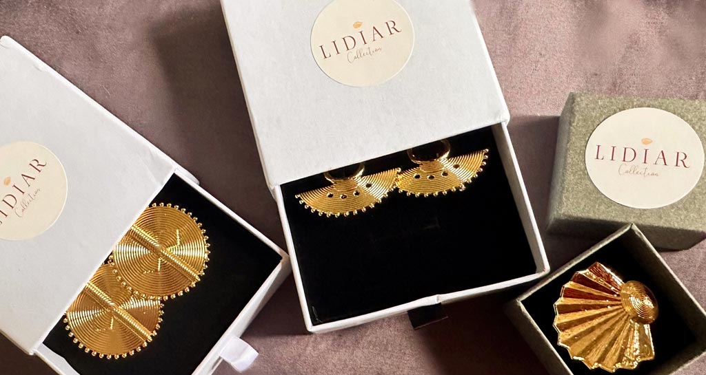 Trois écrin à bijoux dont deux avec des boucles d'oreilles dorées ethniques et une bague dorées