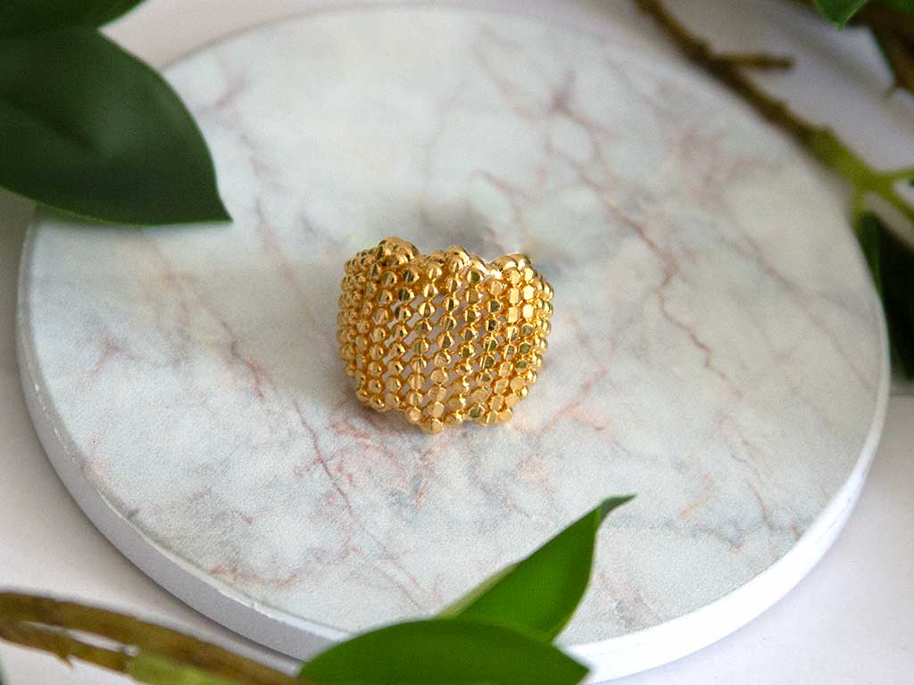 bague dorée posée sur un plateau en marbre