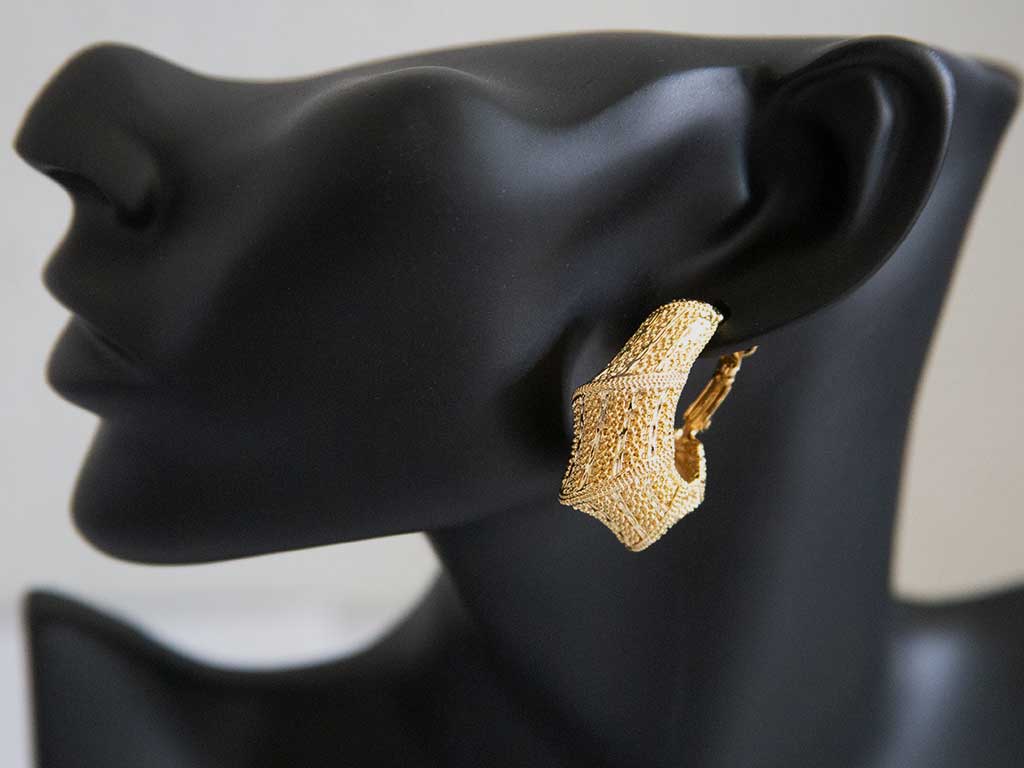 tête de mannequin portant une boucle d'oreille dorée