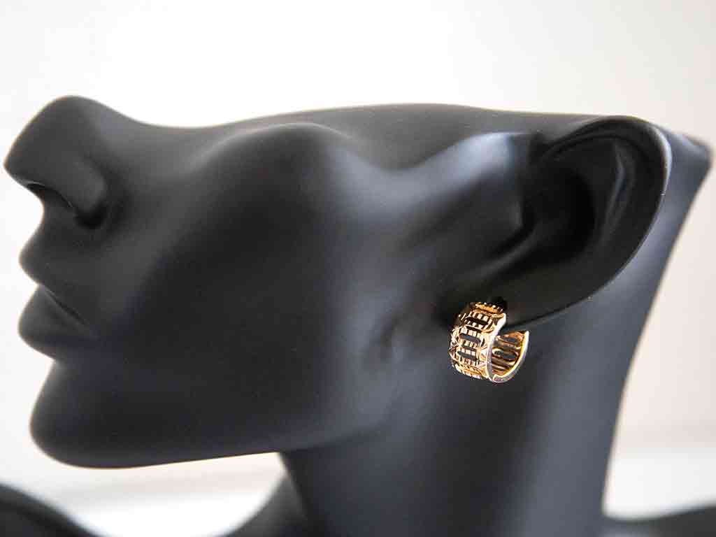 tête de mannequin portant une boucle d'oreille huggies dorée