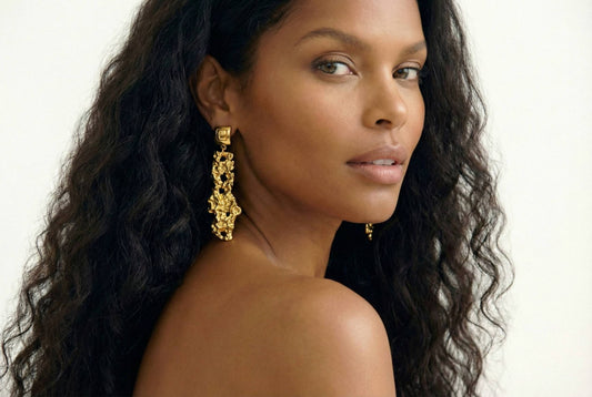 Jeune femme qui porte des boucles d'oreilles dorées effet martelé texturé en acier inoxydable - Modèle Siné par Lidiar Collection