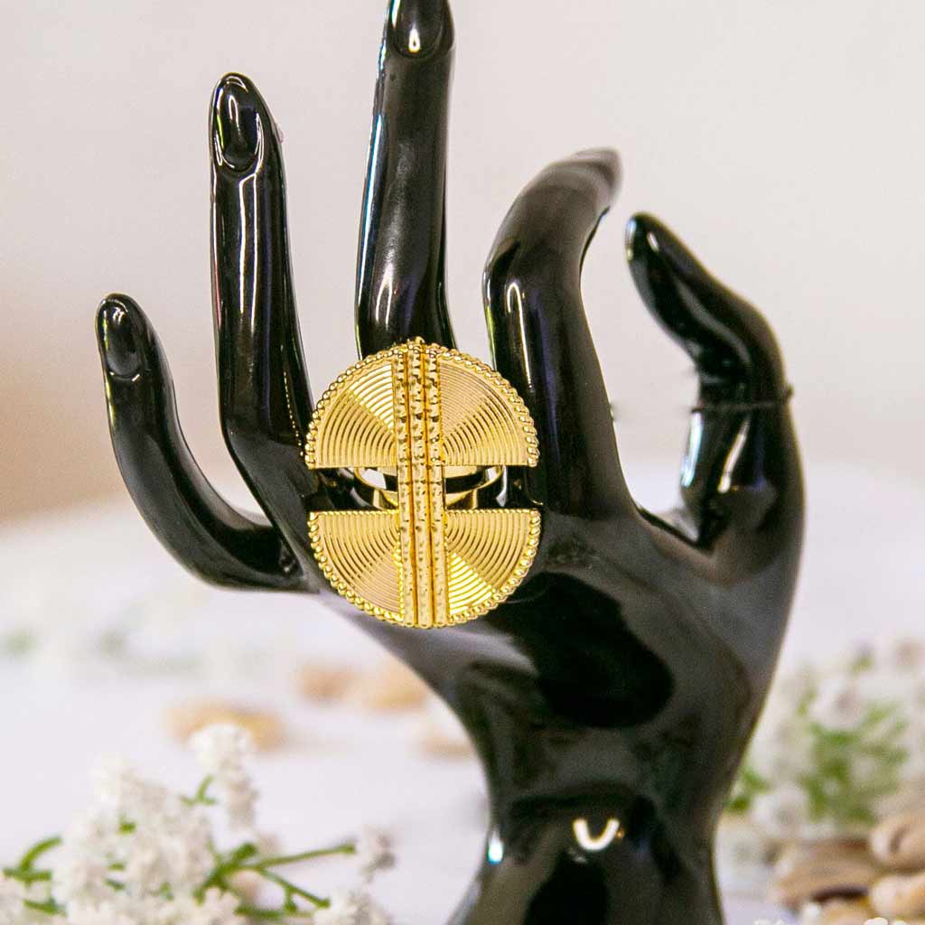 Main de mannequin portant au majeur, une bague dorée de style ethnique