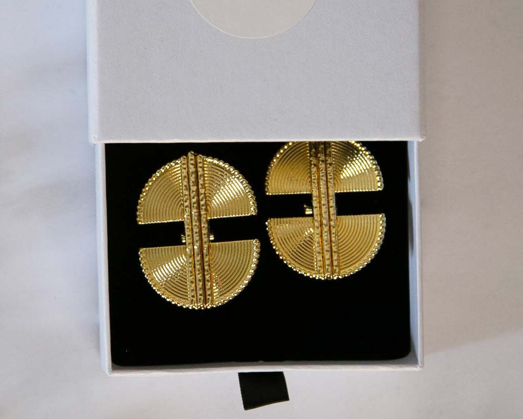 Boucles d'oreilles, style ethnique , dorée posées dans une écrin à bijoux blanc avec un logo lidiar collection