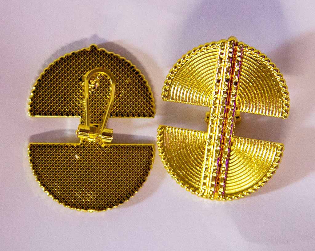 Boucles d'oreilles, style ethnique , dorées, un à l'envers montrant le fermoir de la boucle l'autre à l'endroit