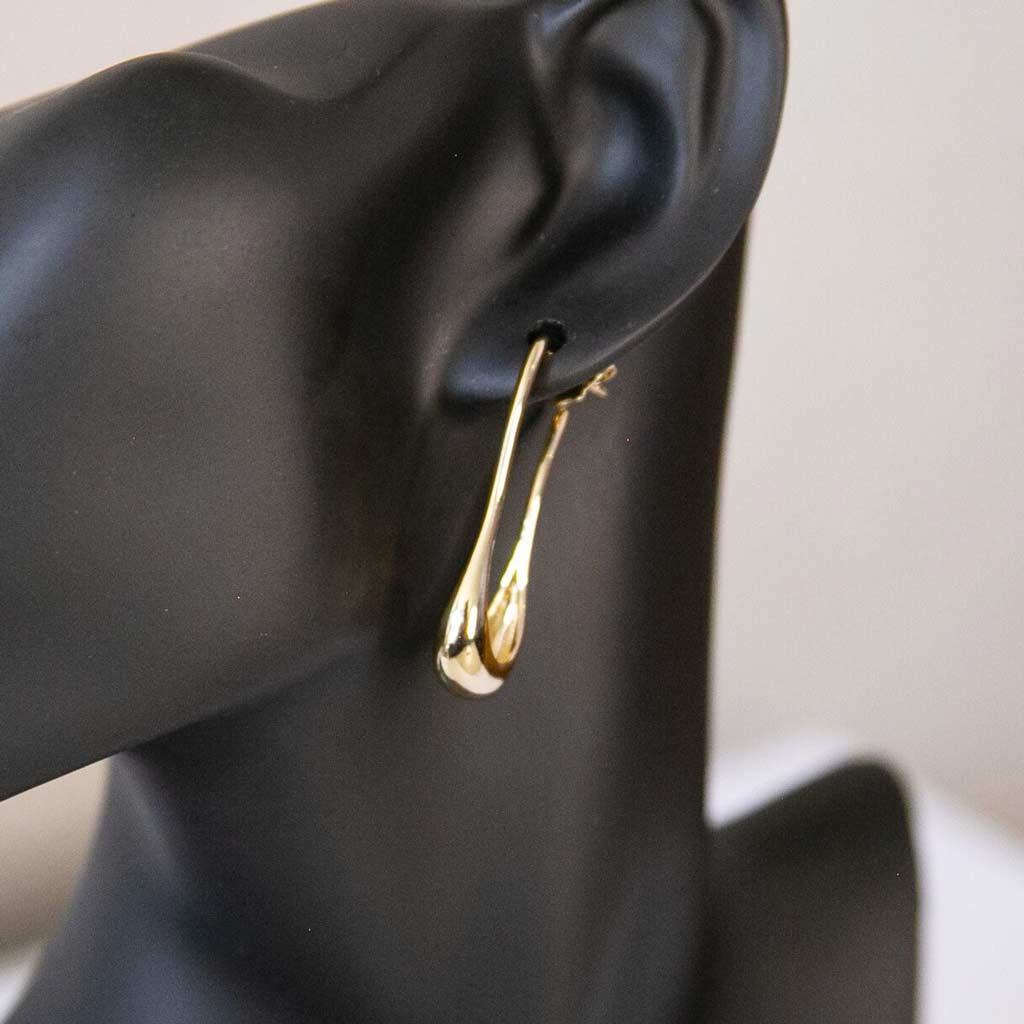 Tête de mannequin portant une boucle d'oreille dorée, en acier inoxydable