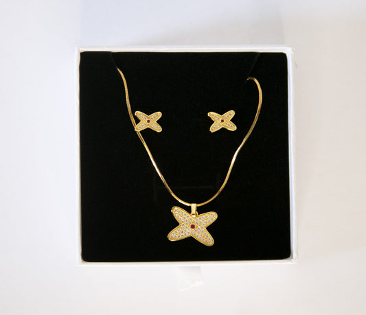 ensemble de boucle d'oreille et de collier en forme de fleure avec strass blanc et rouge, dans un écrin à bijoux