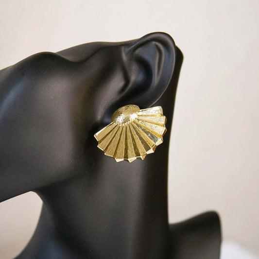 Tête de mannequin portant une boucle d'oreille de style ethnique dorée