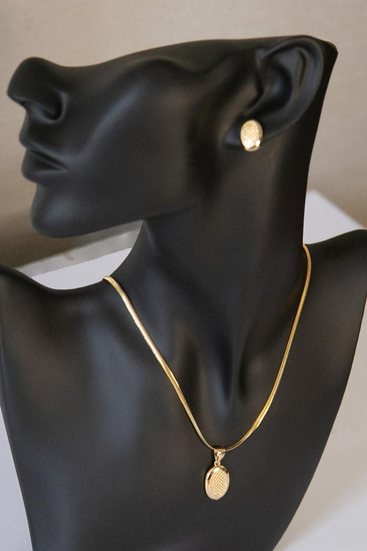 tête de mannequin portant un ensemble de boucle d'oreille et de collier