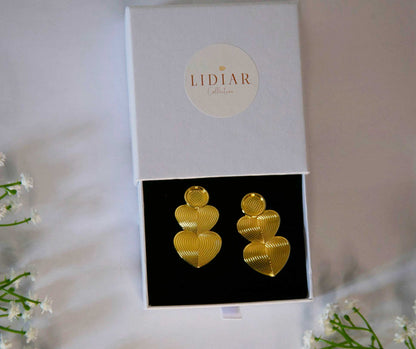 boucles d'oreilles dorées en forme de coeurs dans un écrin à bijoux lidiar collection