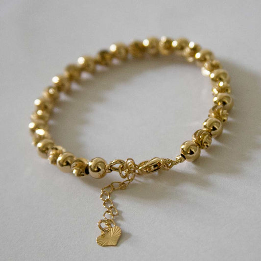Bracelet en acier inoxydable, doré,  constitué d'une suite de perle doré, avec un pendentif coeur, 