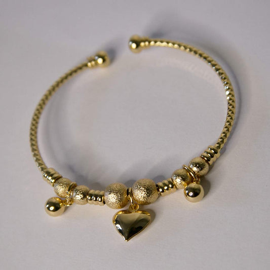 Un bracelet en acier inoxydable, doré, avec un pendentif coeur et des boules
