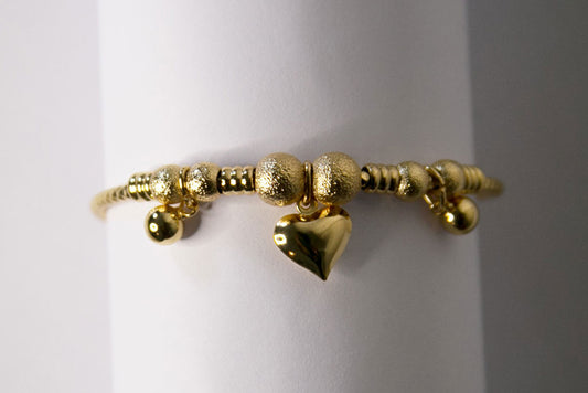 Un bracelet en acier inoxydable, doré, avec un pendentif coeur et des boules