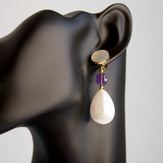 tête de mannequin portant une boucle d'oreille nacrée avec perle et gemme améthyste 