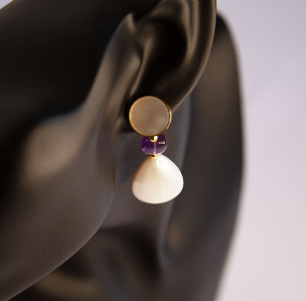 tête de mannequin portant une boucle d'oreille nacrée avec perle et gemme améthyste