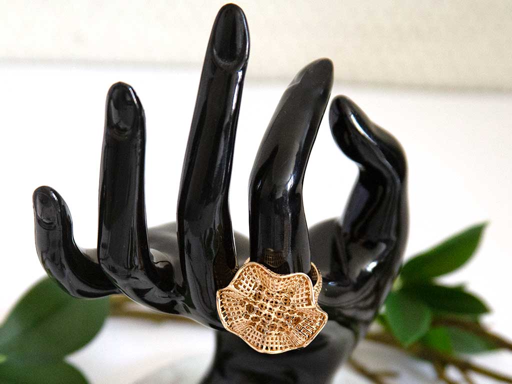 main de mannequin portant une bague en forme de fleure