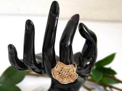 main de mannequin portant une bague en forme de fleure