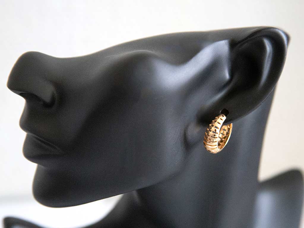 tête de mannequin portant une petite boucle d'oreille dorée