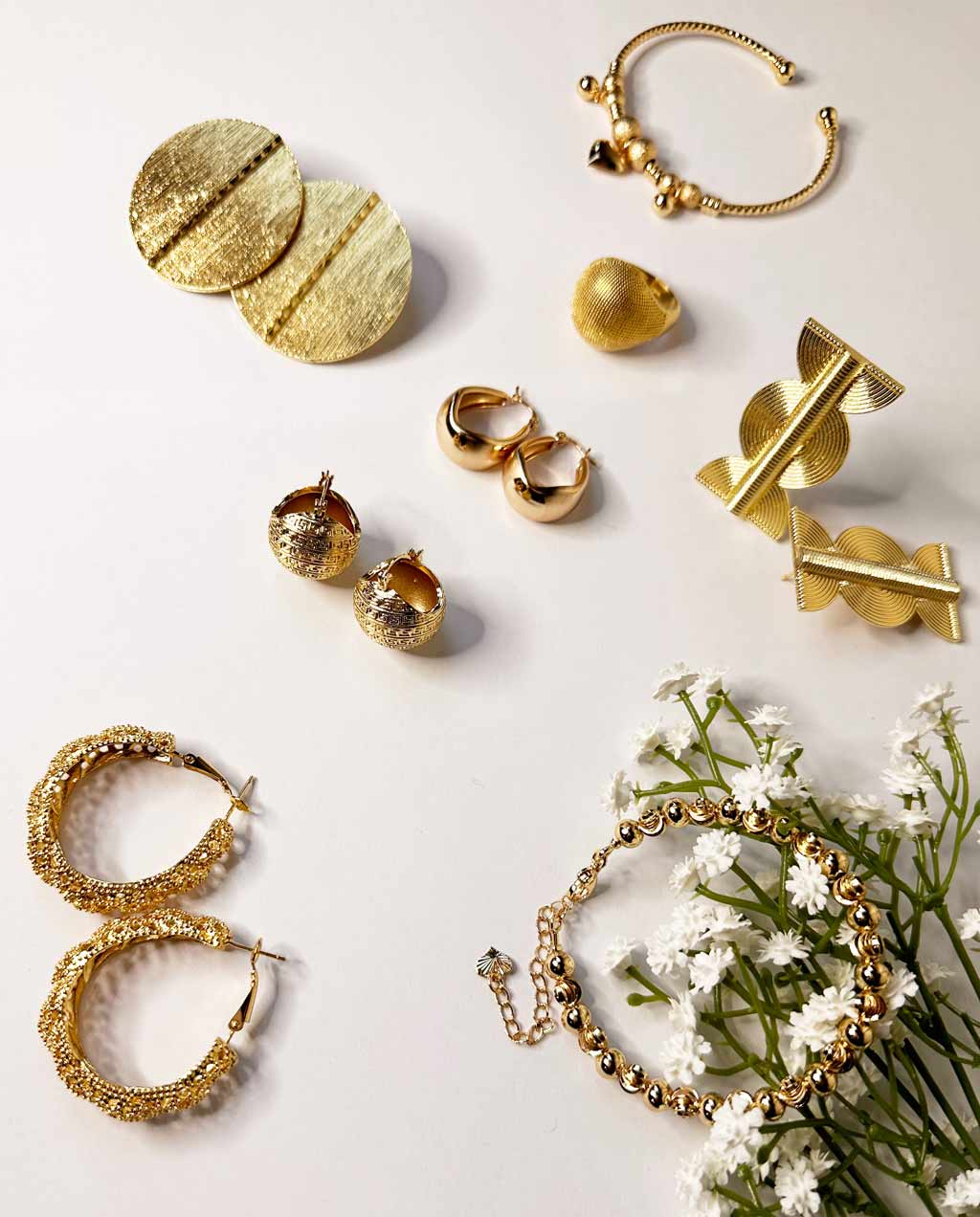 Photo de bijoux, boucles d'oreilles, bagues et bracelets dorés