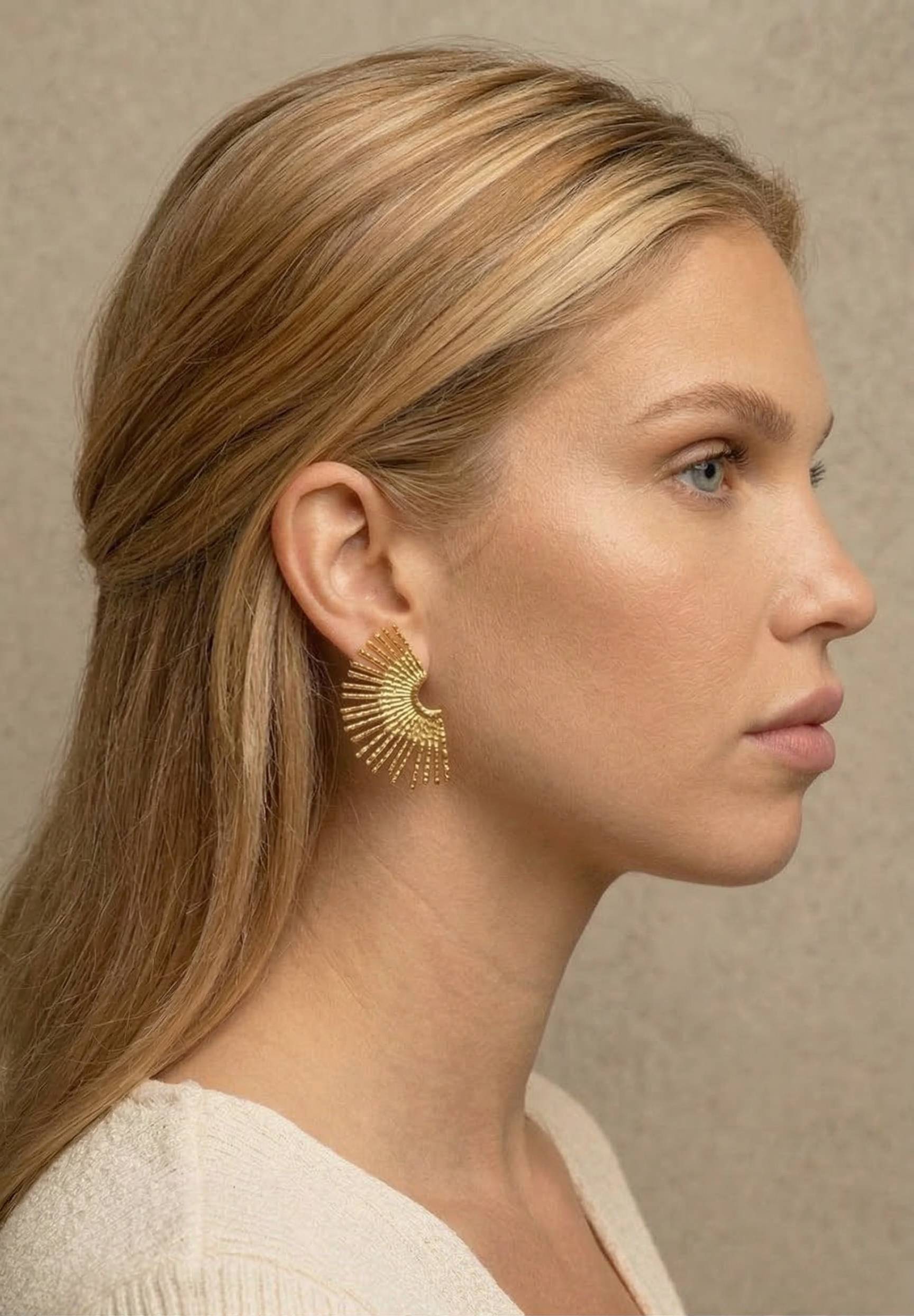 jeune femme blonde portant des Boucles d’oreilles dorées rayonnantes texturées, design éventail élégant – Lidiar Collection