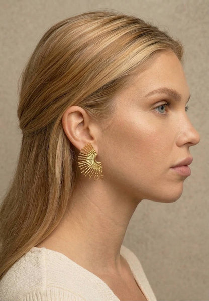 jeune femme blonde portant des Boucles d’oreilles dorées rayonnantes texturées, design éventail élégant – Lidiar Collection