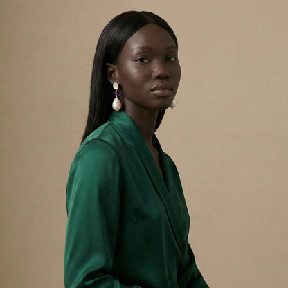 Jeune femme portant des Boucles d’oreilles pendantes dorées avec nacre naturelle, perle baroque et pierre violette style améthyste – bijou élégant Lidiar Collection