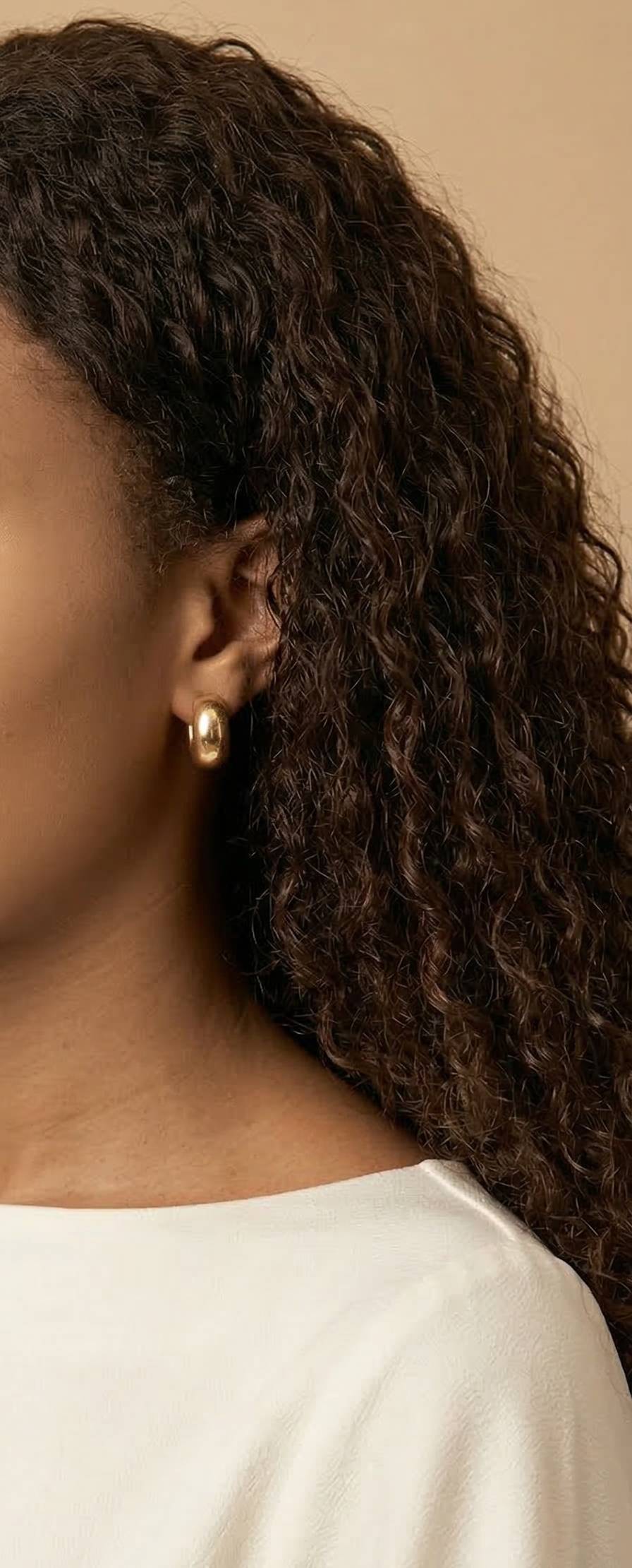 jeune femme portant des Boucles d’oreilles clip dorées rondes pour oreilles non percées en acier inoxydable – Lidiar Collection