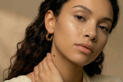 jeune femme portant des Boucles d’oreilles créoles dorées avec perles marron effet ambre, design élégant – Lidiar Collection