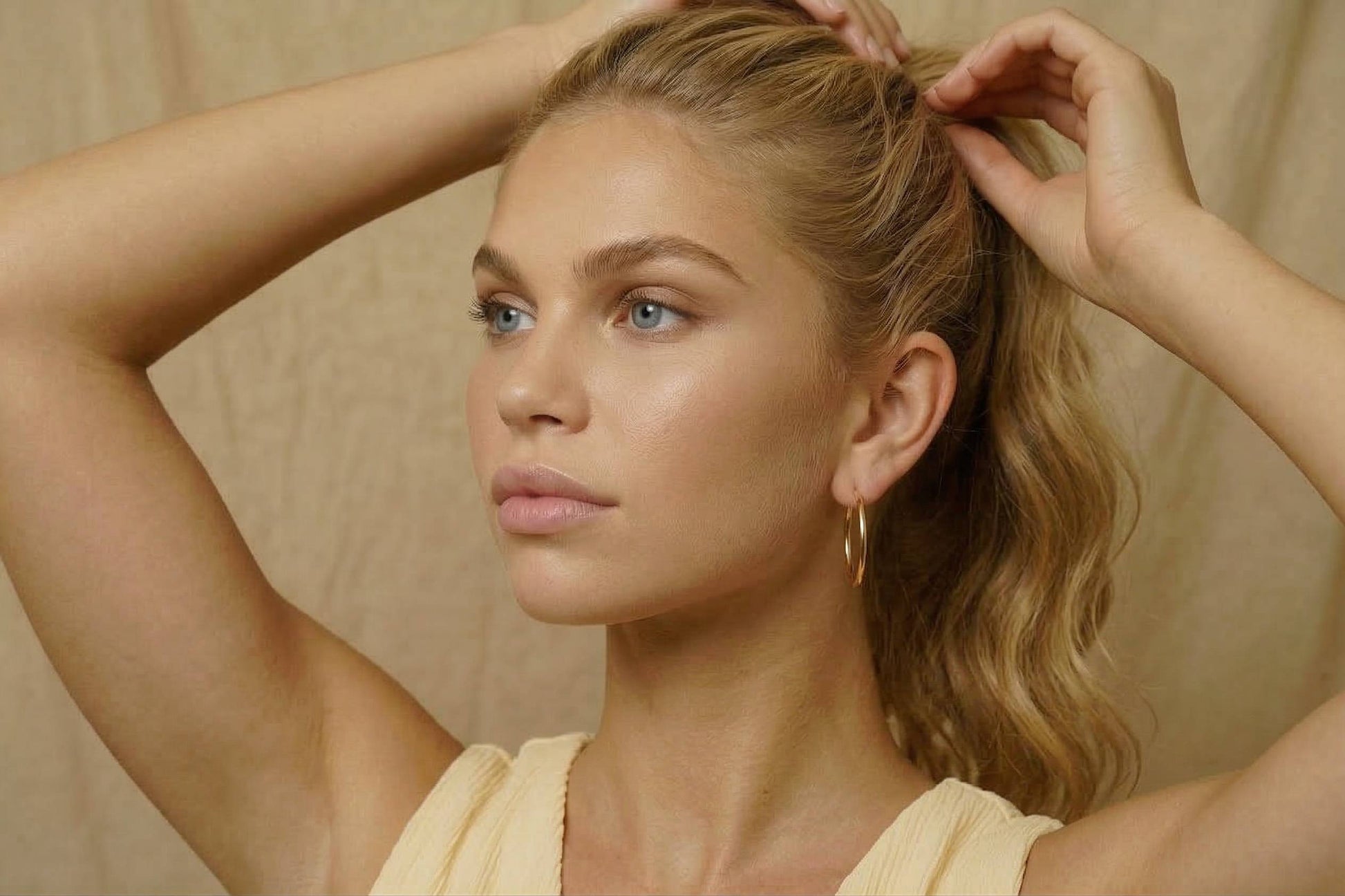 jeune femme portant des Boucles d’oreilles créoles dorées fines en acier inoxydable, design minimaliste – Lidiar Collection