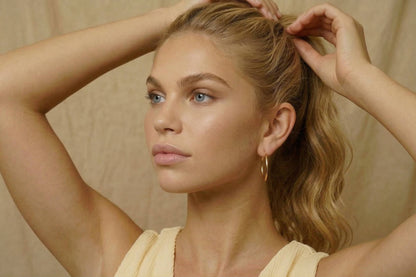 jeune femme portant des Boucles d’oreilles créoles dorées fines en acier inoxydable, design minimaliste – Lidiar Collection