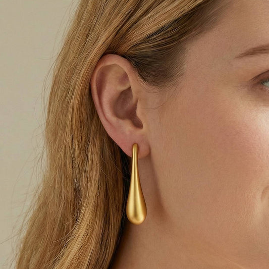 Jeune femme portant Boucles d’oreilles pendantes dorées en forme de goutte, design minimaliste et élégant – Lidiar Collection