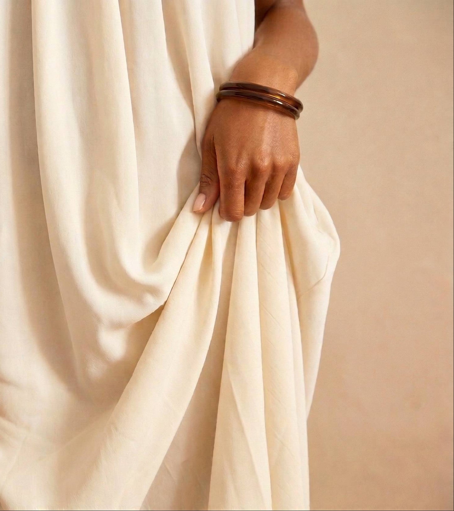 bras portant au poignet un Bracelets jonc en résine effet ambre marron foncé, design minimaliste et élégant – Lidiar Collection 