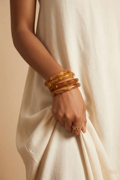 femme portant 4 Bracelets en résine effet ambre marron et miel, design élégant et moderne  et une bague dorée en acier inoxydable– Lidiar Collection