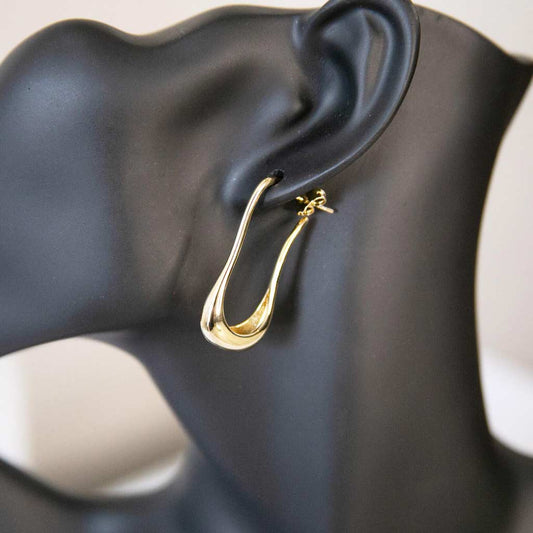 Tête de mannequin portant une boucle d'oreille dorée, en acier inoxydable
